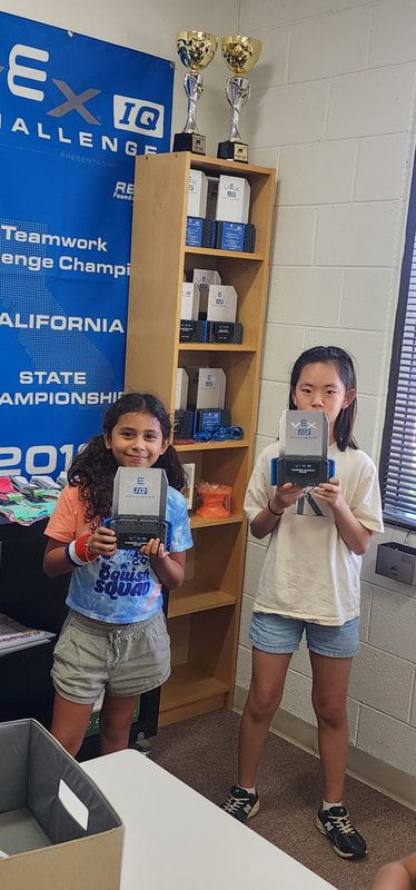 Two children proudly holding their robot controllers