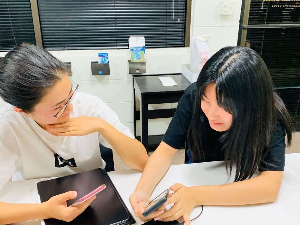 Two members looking at a phone together