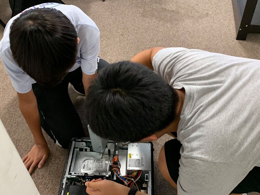 Two members looking inside a computer