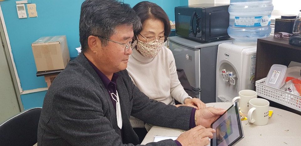 Two Voice of Calling supporters setting up a tablet