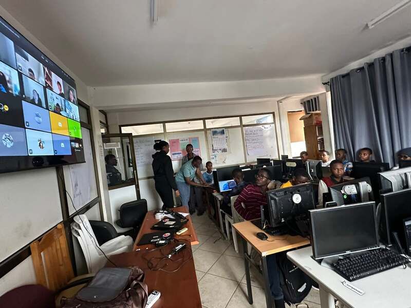 A Tanzanian computer lab with a wall screen used for the live Zoom class with Voice of Calling teachers